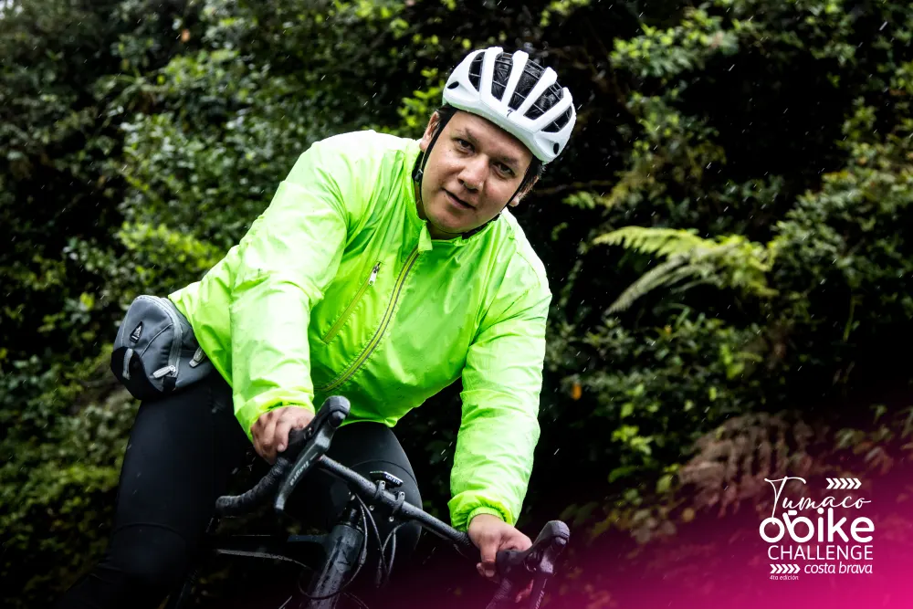 Ciclista sonriendo bajo la lluvia