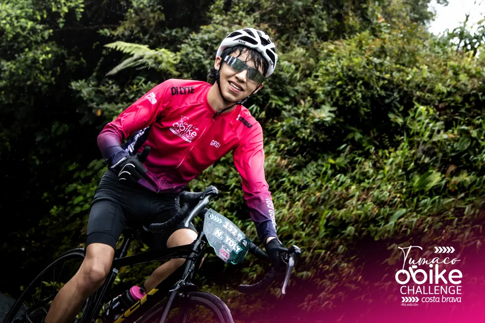 Ciclista con jersey oficial rosado con los brazos abiertos