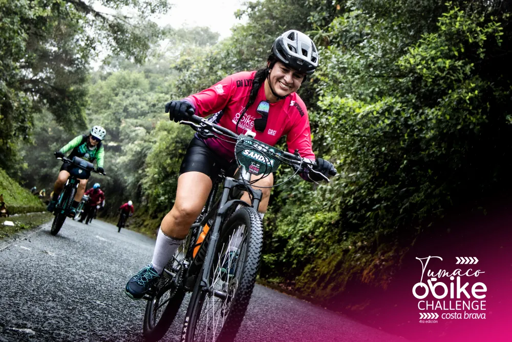Ciclista con el jersey oficial rosado en plena ruta bajo la lluvia